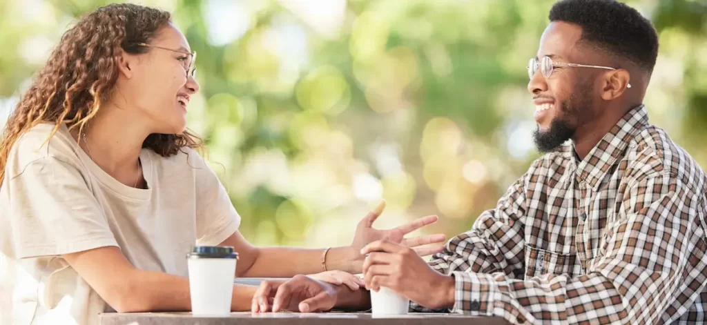 Twee mensen genieten van gezellig gesprek buiten.