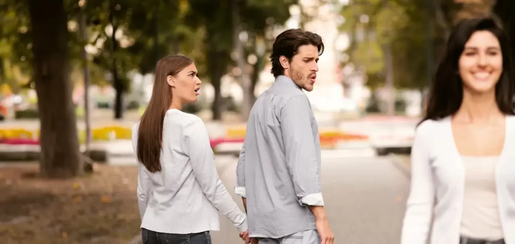 Man kijkt naar andere vrouw terwijl vriendin boos is